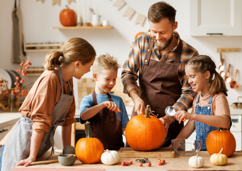 Foto di famiglia che prepara le zucche per halloween