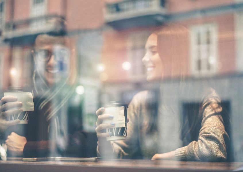 Foto di ragazzi che prendono un caffè in vetrina al bar