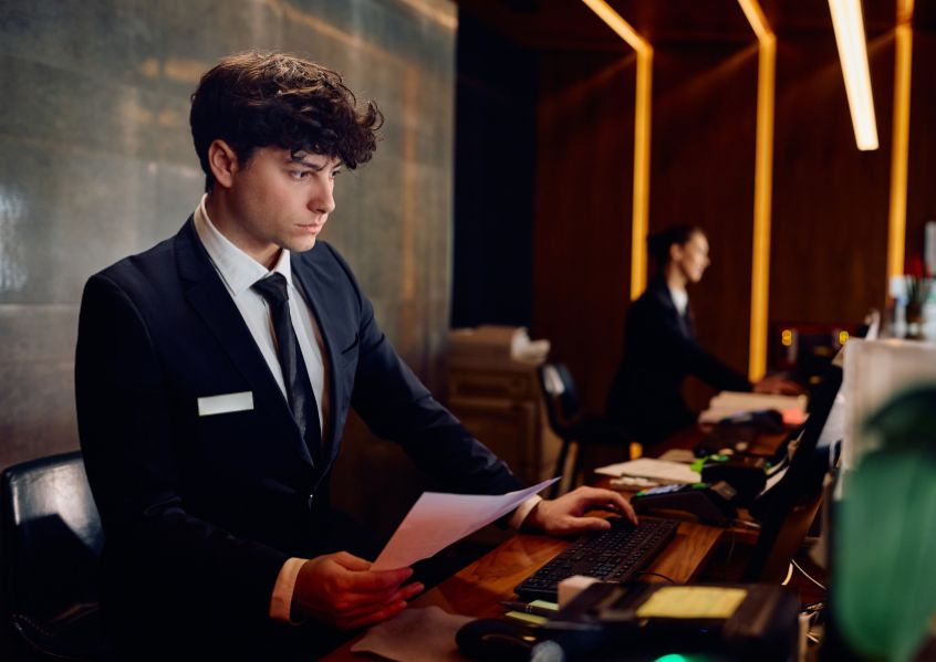 Foto di ragazzo che lavora alla reception di un albergo