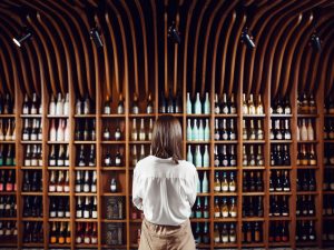 Foto di donna di spalle che guarda la cantina dei vini