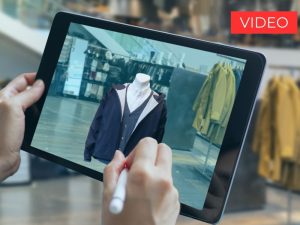 Foto di tablet tenuto in mano in un negozio di vestiti
